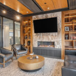 Lounge area speakeasy with bar and fireplace with tv.