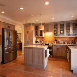Quartersawn White Oak kitchen in a light Pampas finish with small island and stainless steel appliances.