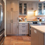 Quartersawn White Oak kitchen in a light Pampas finish with small island and stainless steel appliances.