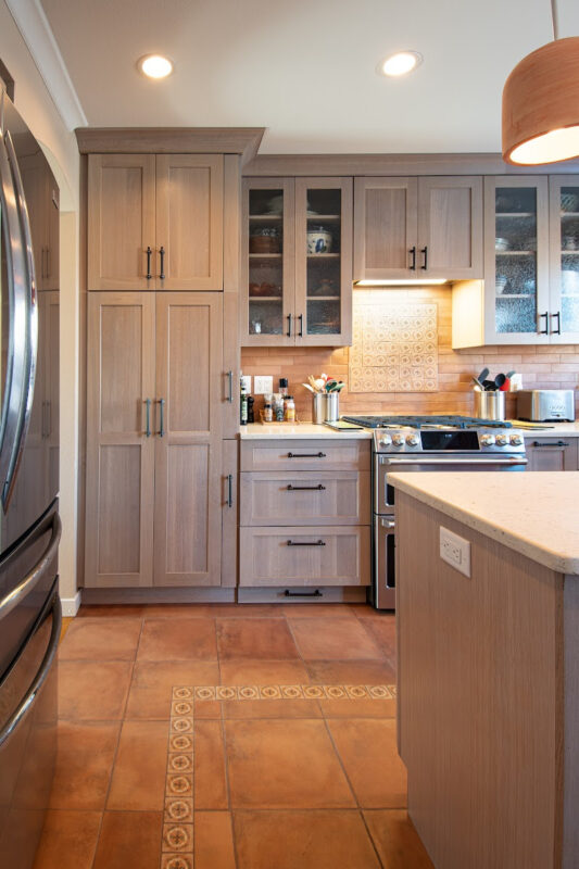 Quartersawn White Oak kitchen in a light Pampas finish with small island and stainless steel appliances.