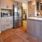 Quartersawn White Oak kitchen in a light Pampas finish with small island and stainless steel appliances.