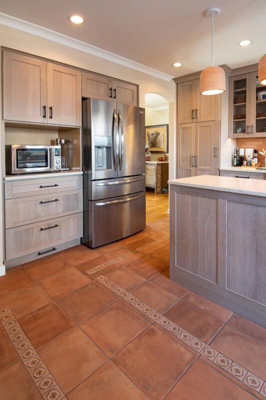 Quartersawn White Oak kitchen in a light Pampas finish with small island and stainless steel appliances.