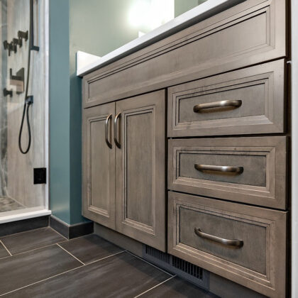 Brown stained bathroom vanity next to a glass steam shower.