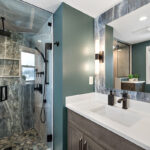 Brown stained bathroom vanity next to a glass steam shower.
