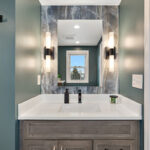 Brown stained bathroom vanity next to a glass steam shower.