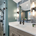 Brown stained bathroom vanity next to a glass steam shower.