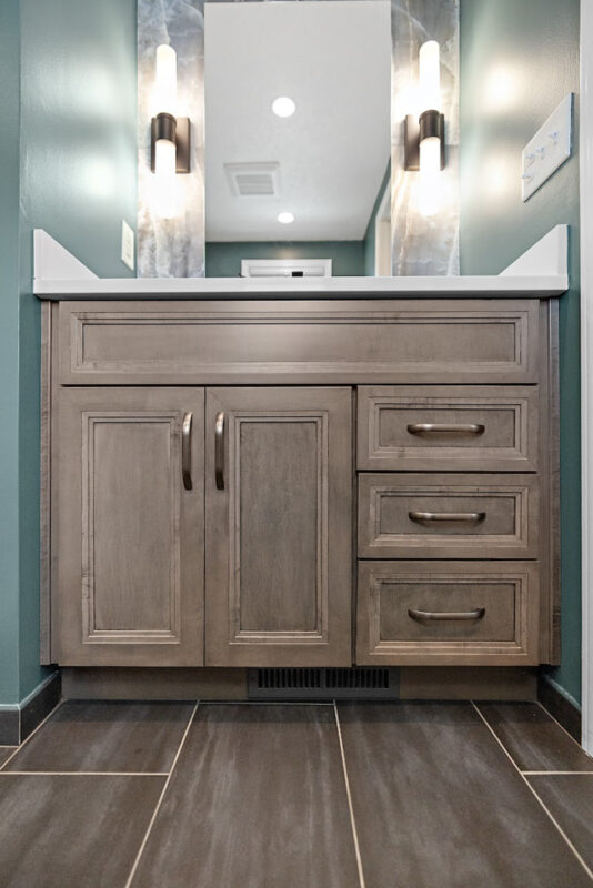 Brown stained bathroom vanity next to a glass steam shower.