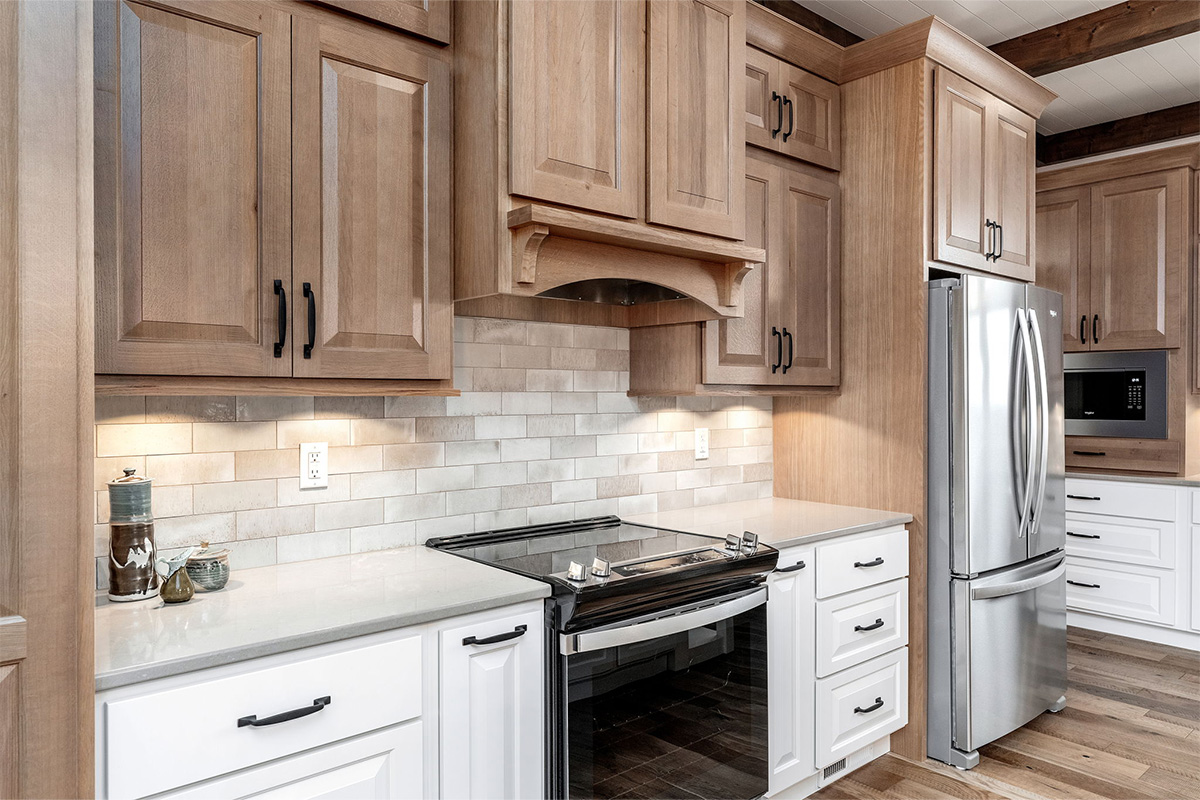 Brown-stained and white kitchen cabinets with black oven.