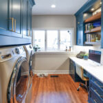 Emerald blue laundry and office space with dog crate cabinet.