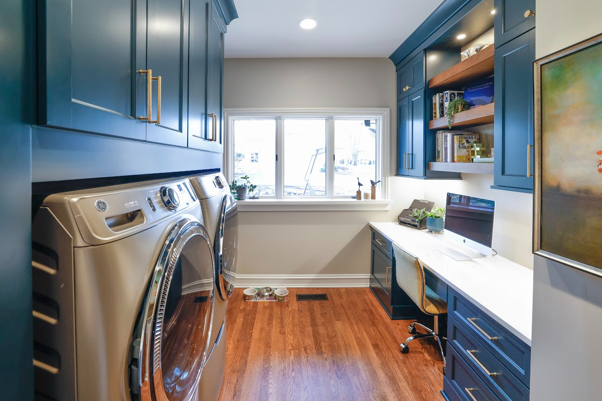 Emerald blue laundry and office space with dog crate cabinet.
