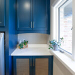 Emerald blue laundry with dog crate cabinet.