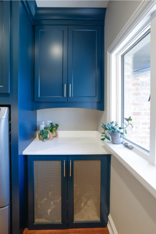 Emerald blue laundry with dog crate cabinet.