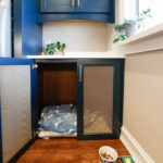 Emerald blue laundry with dog crate cabinet.
