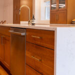 Cherry kitchen cabinets with a red Sienna stain. Shows the island with sink.