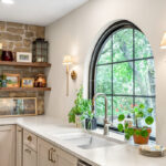 Large arched window above kitchen sink and other cabinets with Light Mocha paint.