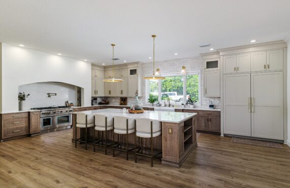 Light brown-stained lower and kitchen cabinets with gray painted uppers.