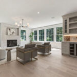 Light Mocha-painted wet bar cabinets near a living room with fireplace.