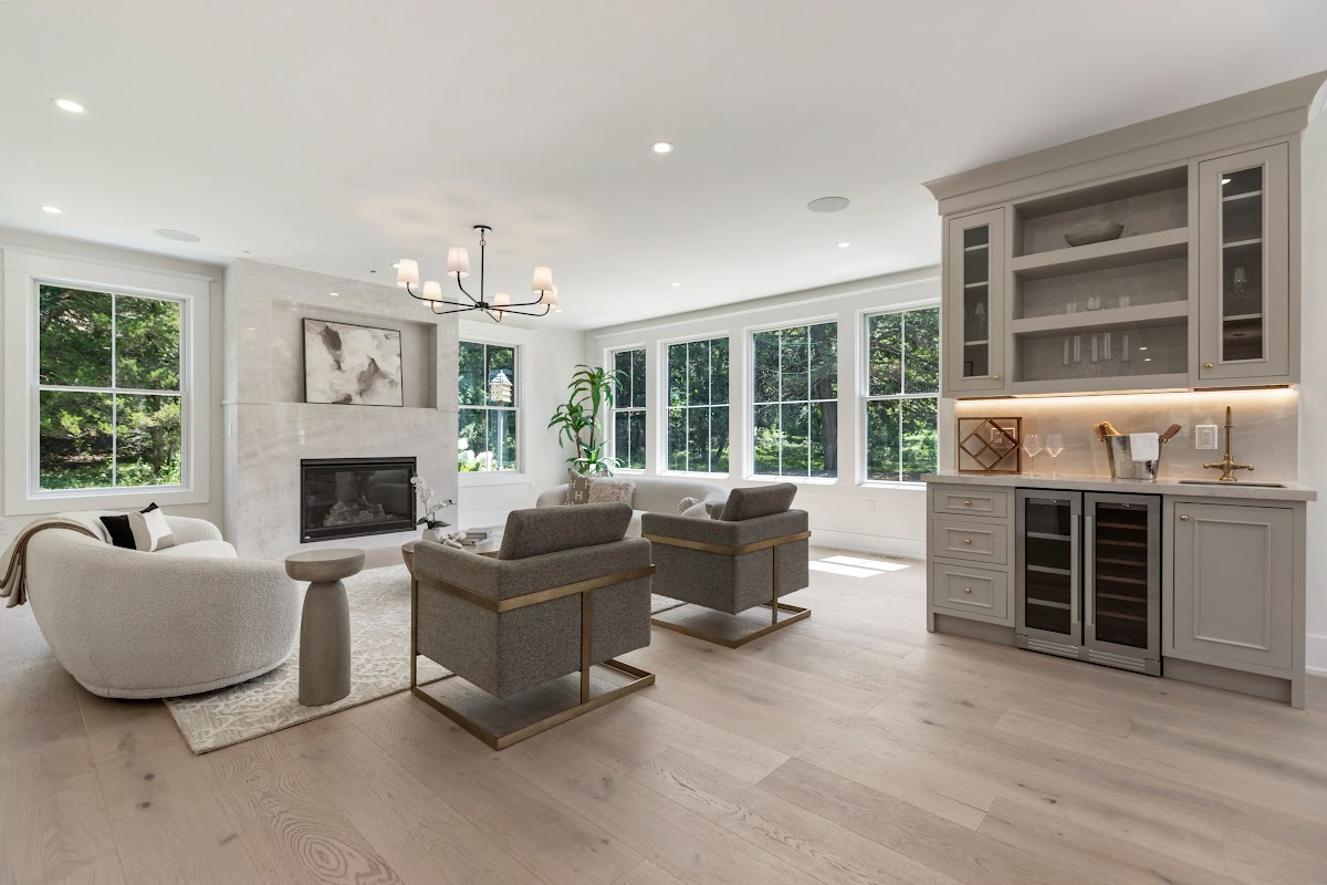 Light Mocha-painted wet bar cabinets near a living room with fireplace.