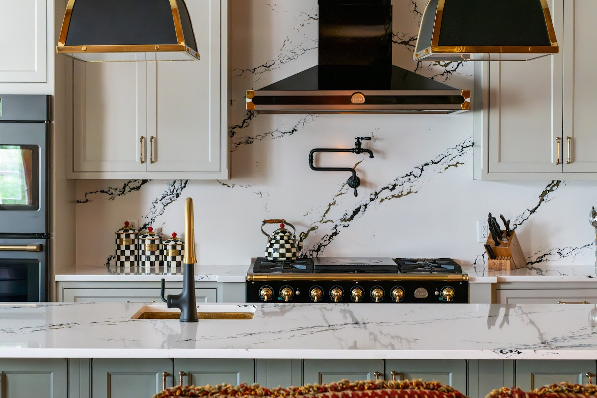 Painted Oyster primary kitchen cabinets with black appliances and green island.