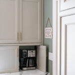 Painted gray kitchen cabinets with appliance storage door open