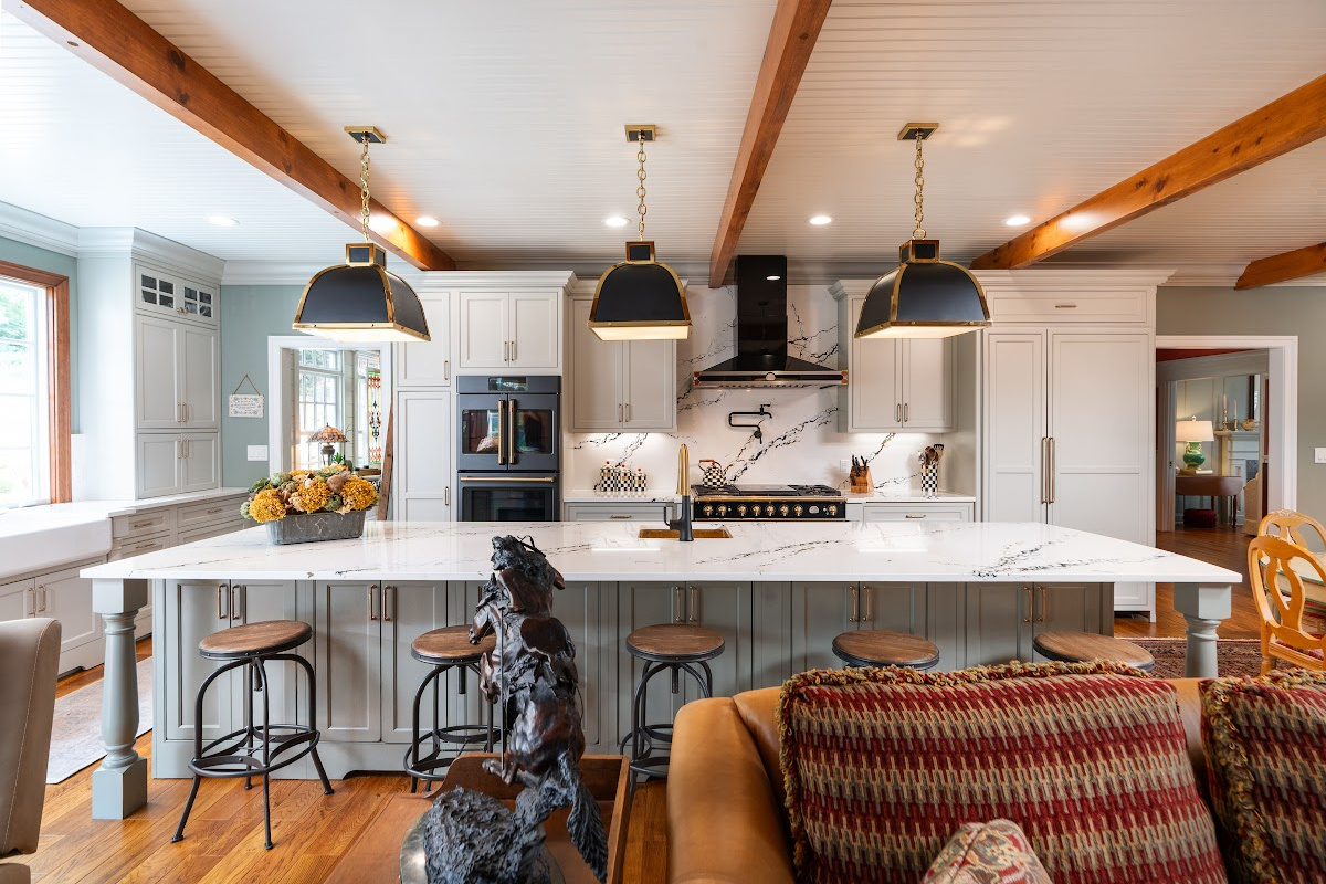 Painted Oyster primary kitchen cabinets with black appliances and green island.