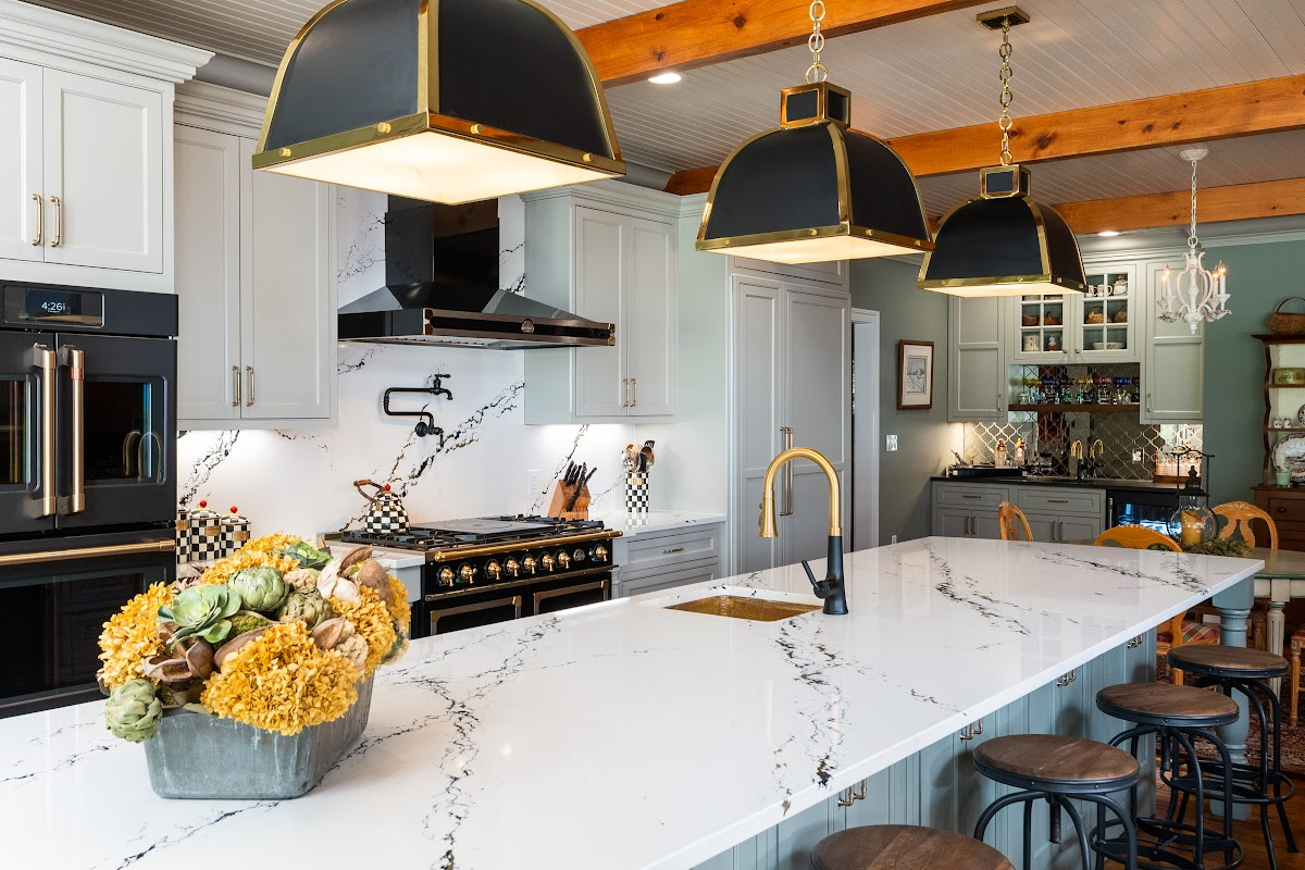 Painted Oyster primary kitchen cabinets with black appliances and green island.