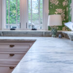 White kitchen cabinets. View of window and counter top.