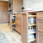 Kitchen cabinets with pullout accessory kits open.