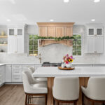 kitchen with white perimeter and stained rift white oak island cabinets.