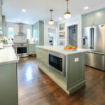 Light green painted kitchen with island.