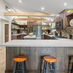 Rustic Alder kitchen with ceiling beams and floating shelves.