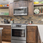 Rustic Alder kitchen with ceiling beams and floating shelves.