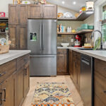 Rustic Alder kitchen with ceiling beams and floating shelves.