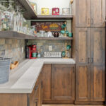 Rustic Alder kitchen with ceiling beams and floating shelves.