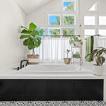 Bright and airy bathroom with several windows above the tub that has black door panel covering the front.