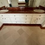 Serenity Starts Here "before" photo of white cabinets with a dark marble counter