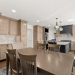 Kitchen cabinets with light brown stain. Shows a gray painted wood hood and stainless steel oven.