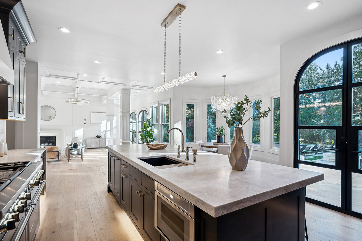 Kitchen with dark Iron Ore painted cabinets and a white hood. Includes a long island with seating.