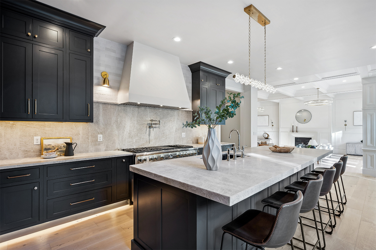 Kitchen with dark Iron Ore painted cabinets and a white hood. Includes a long island with seating.