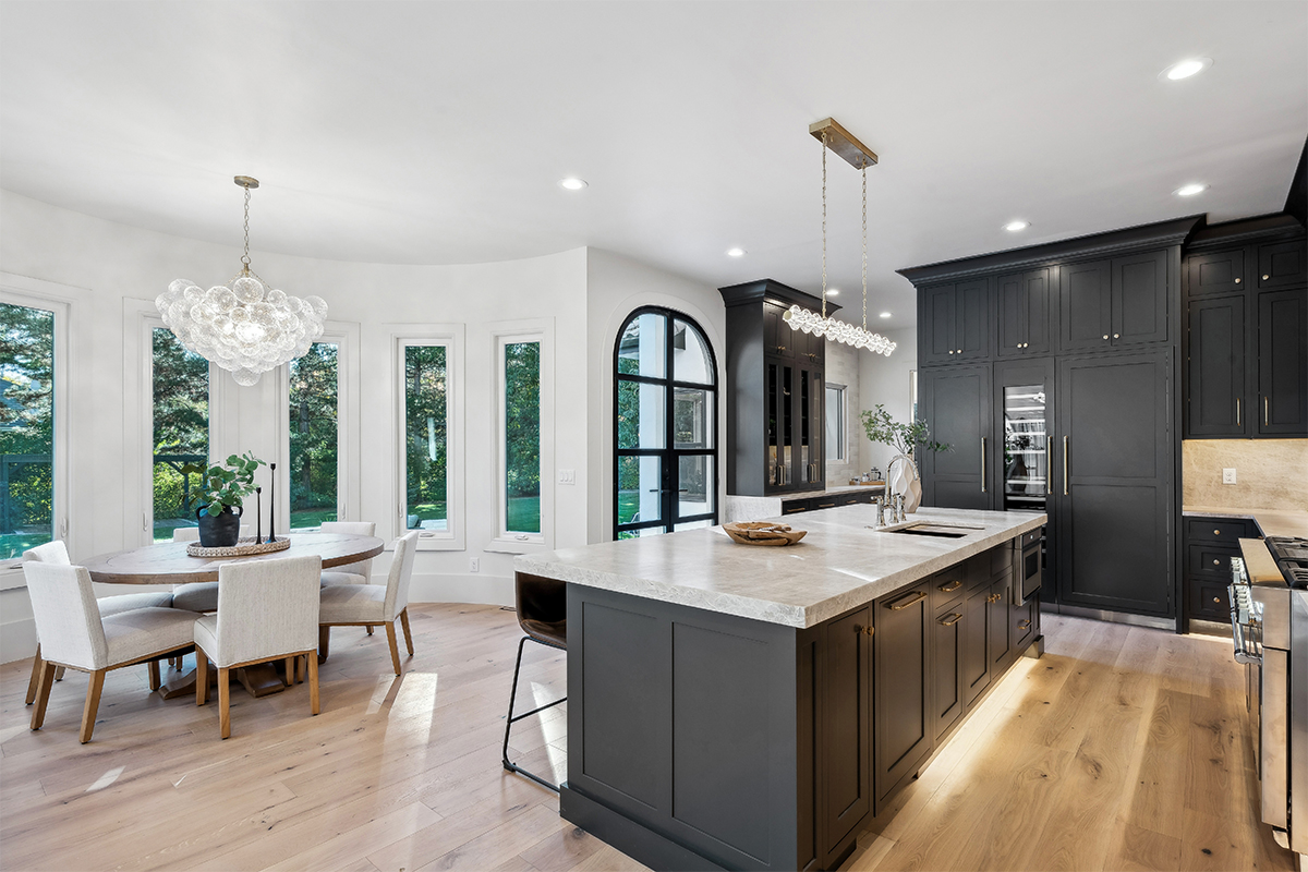 Kitchen with dark Iron Ore painted cabinets and a white hood. Includes a long island with seating.