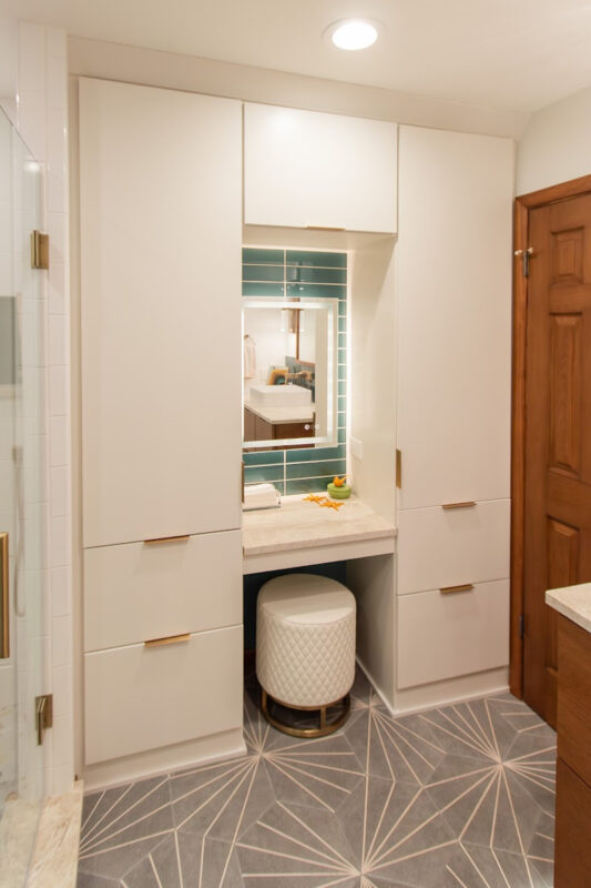 White painted linen cabinets with powder desk mounted between them.