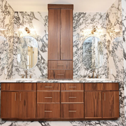 Walnut bathroom cabinets in Natural with walls and floors made of marble.