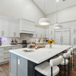 White kitchen perimeter cabinets with blue island.