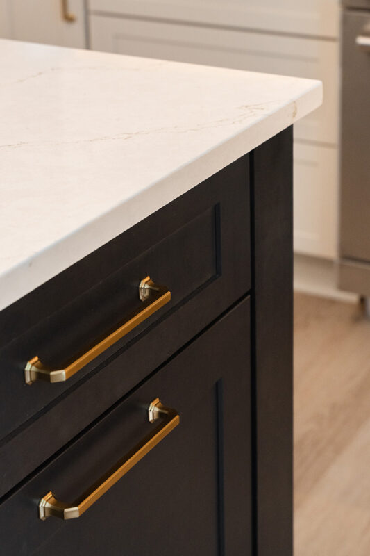 Light Mocha painted perimeter kitchen cabinets and an island with dark stained hood and island.