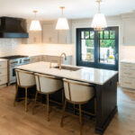 Light Mocha painted perimeter kitchen cabinets and an island with dark stained hood and island.