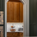 Quartersawn White Oak Natural pantry cabinets viewed through an arched walkway.