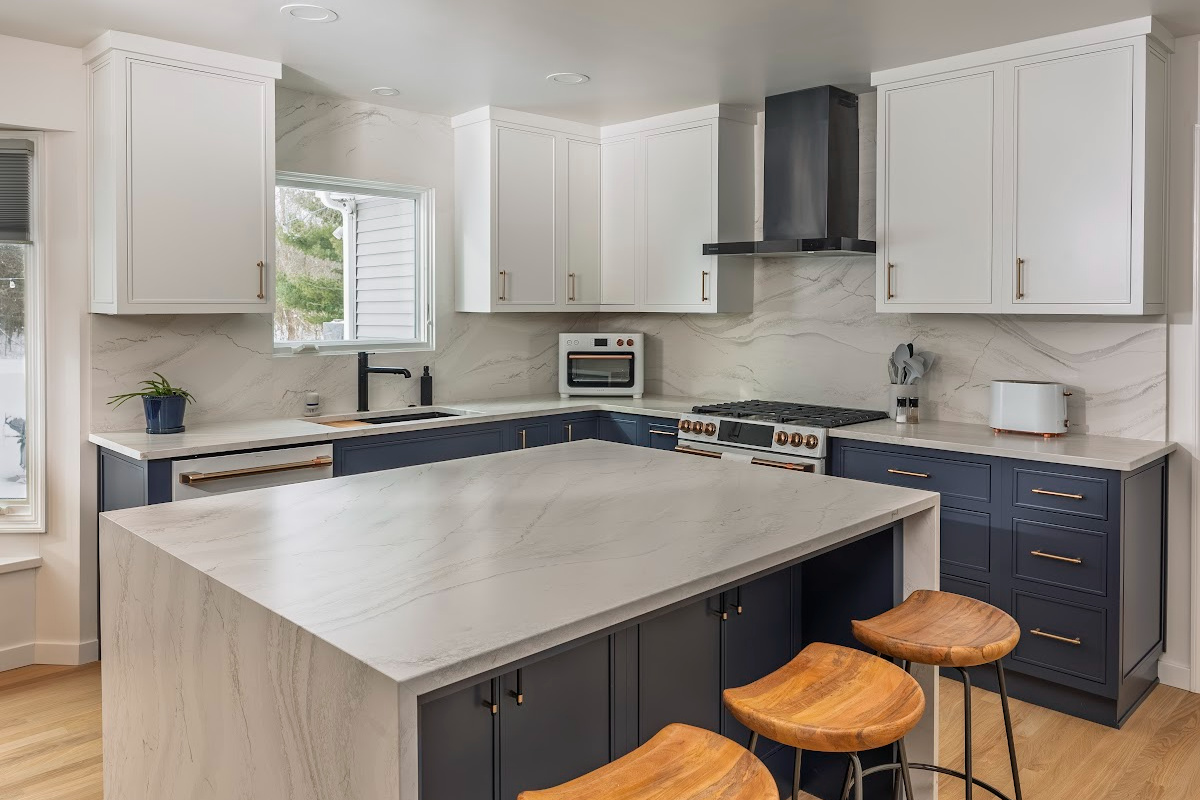 Blue and white kitchen cabinets with white appliances.