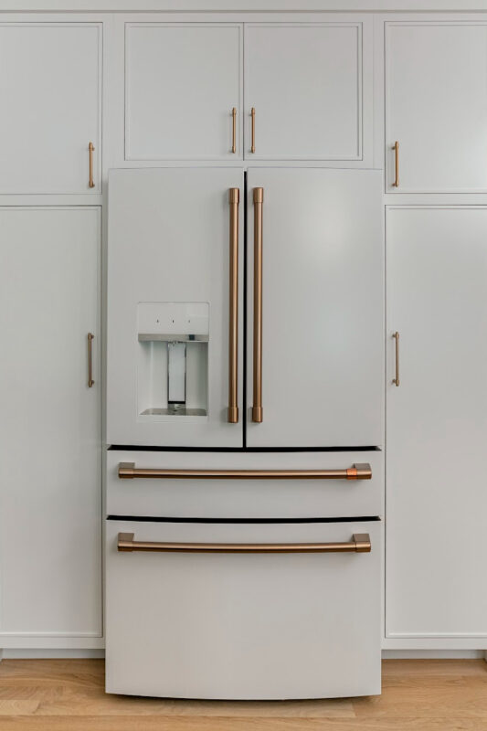 White kitchen cabinets with white fridge.