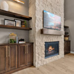 Fireplace with dark stained cabinets on each side.