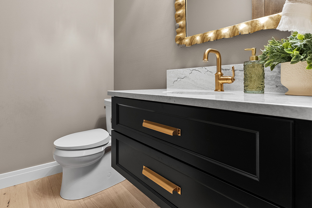 Dark green painted floating vanity with two drawer look in a bathroom.